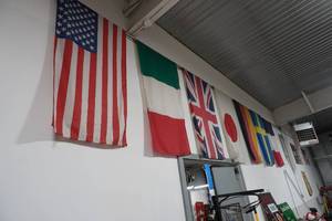 lot 65 image: US Flag & six flags hanging on wall