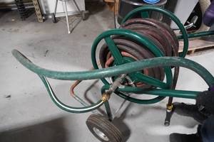 lot 131 image: Garden hose on reel (one bad tire)