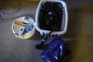 lot 88 image: 2 Garden hoses, sprayer and tarp in basket